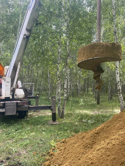Шнек поднимает грунт из скважины под шахту колодца